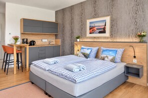 A modern bedroom with a large bed, a desk, and a chair.