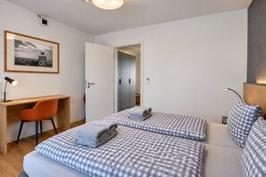 A hotel room with a bed, a desk, and a chair.