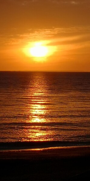 Ein Sonnenuntergang über einem ruhigen Meer mit klarem Horizont.