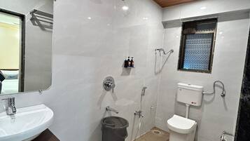 A modern bathroom with a white sink, mirror, and toilet.