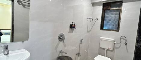 Un baño moderno con lavamanos, espejo y váter blancos.