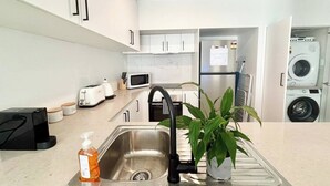 Eine moderne Küche mit Spüle, Mikrowelle, Toaster und Kühlschrank.