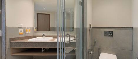 A modern bathroom with a glass-enclosed shower, a sink with a vanity, and a toilet.