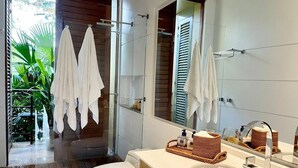 Een moderne badkamer met een douchecabine van glas, een wit toilet en een wastafel met spiegel.