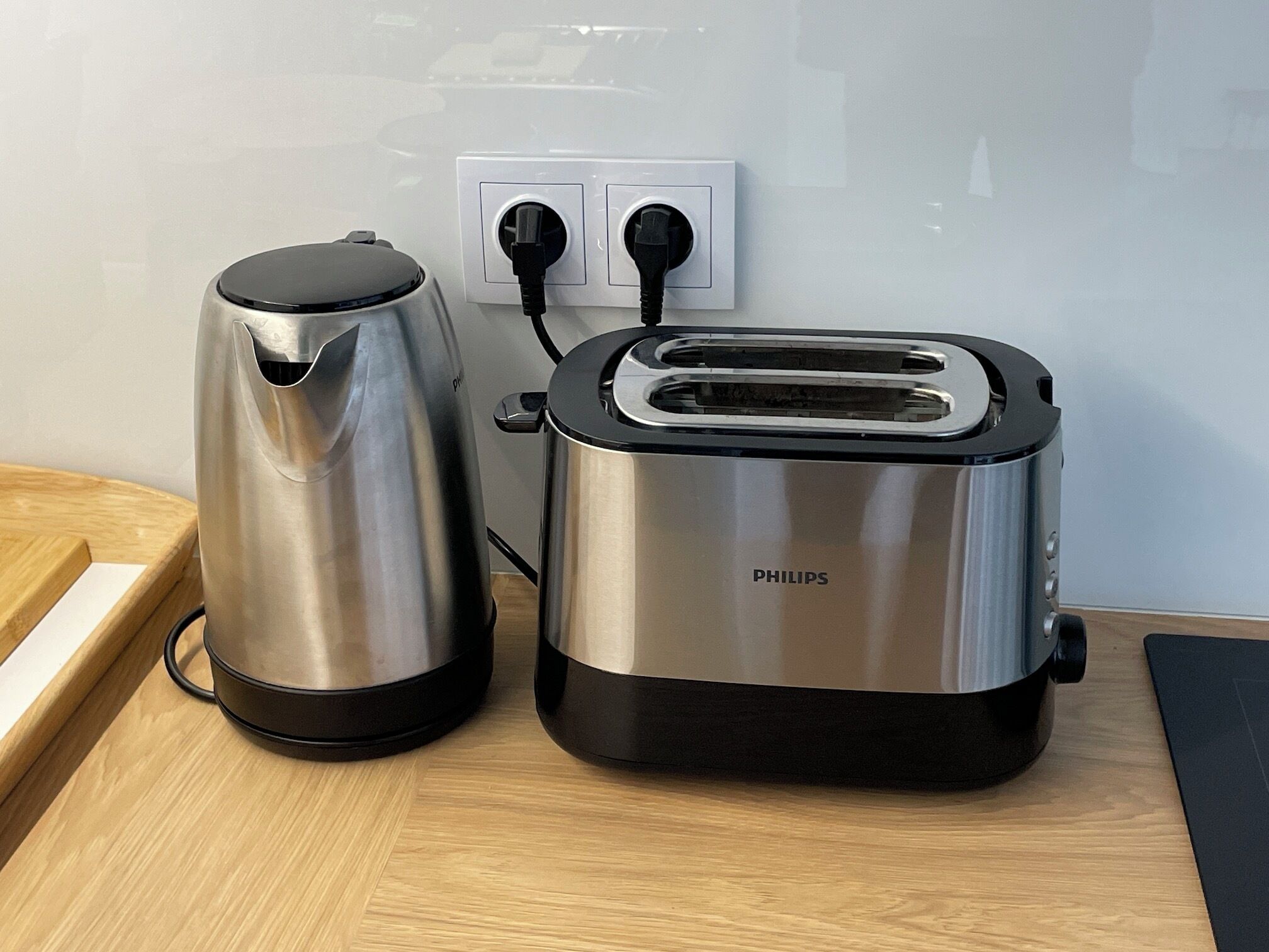 Une cuisine avec une machine à café et un grille-pain posés sur un plan de travail en bois.