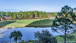 A golf course with a pond, trees, and a clear sky. - Serene 4th Floor Elation Condo: Golf Course and Foliage Views! King Bed, Sleeper Sofa, Kitchenette for Your Convenience at Sandestin Golf and Beach Resort!! (Miramar Beach)