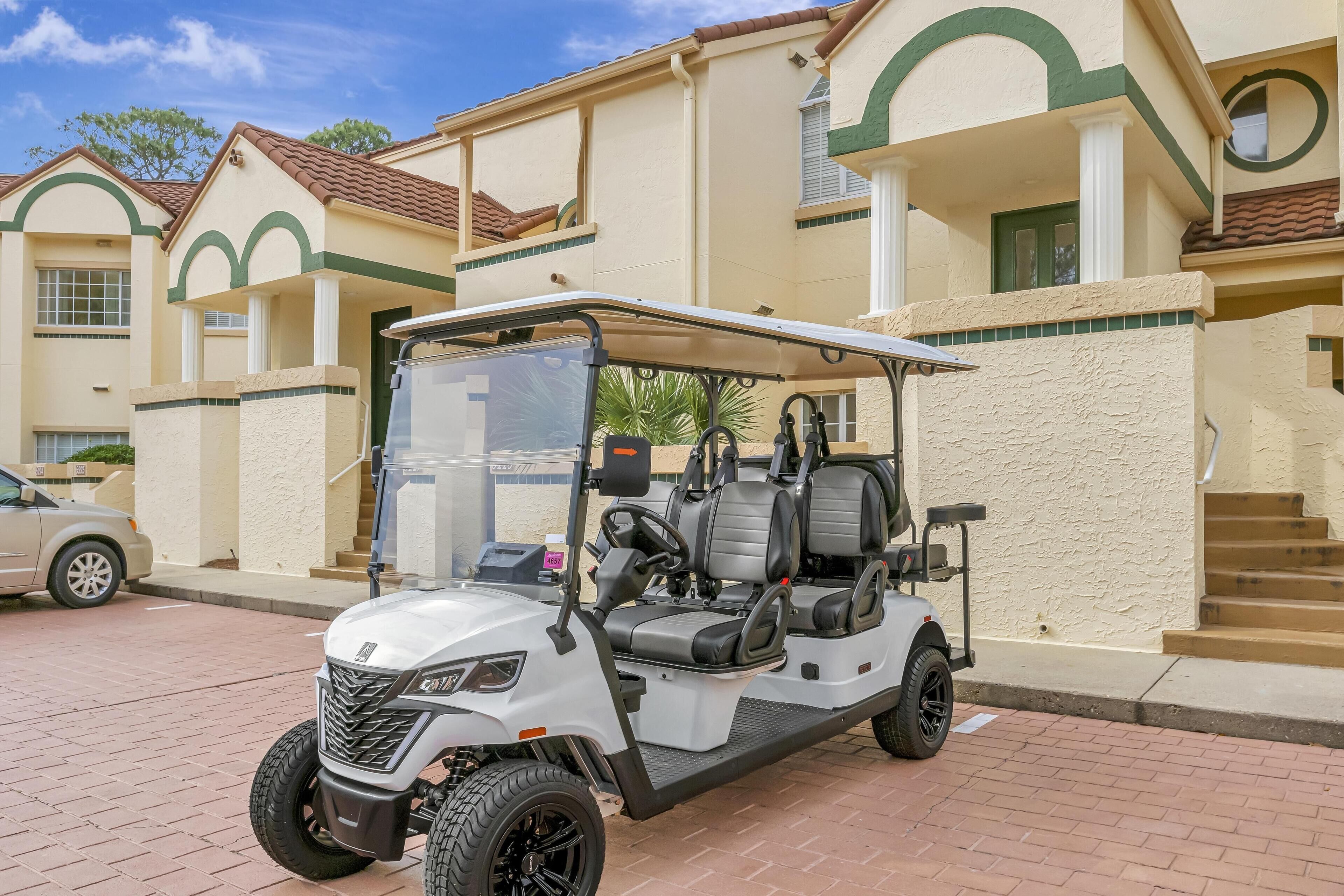A golf cart parked in front of a building with a beige exterior and green trim.