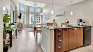 A modern kitchen with a central island, wooden cabinets, and a built-in dishwasher.