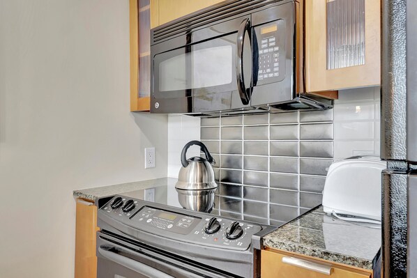 A modern kitchen with stainless steel appliances, including a microwave, oven, and gas stove.