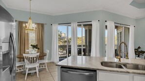 A modern kitchen with a dining area, large windows, and a view of the outdoors. - Spacious 3-Bedroom Retreat with Lake Views (Miramar Beach)