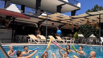 Un área de piscina con sillas de descanso y sombrillas.