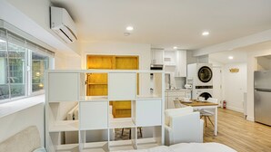 A modern hotel room with a bed, a desk, and a kitchenette. - 3 Mi to Angel Stadium: Cozy Studio w/ Patio! (Santa Ana)
