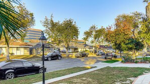 A residential street with parked cars, a lamppost, and houses with visible signage. - 3 Mi to Angel Stadium: Cozy Studio w/ Patio! (Santa Ana)