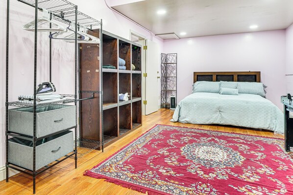 A bedroom with a bed, a wardrobe, a drying rack, and a red patterned rug. - Lake Chabot Getaway ~ 3 Mi to Water! (Castro Valley)
