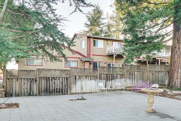 A residential area with a wooden fence, a small garden, and a building with a balcony.
