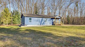 A single-story house with a front porch, a small deck, and a well-maintained lawn.