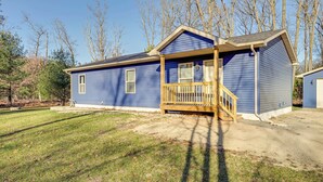 A two-story blue house with a wooden porch and a small staircase leading to the entrance. - Golf, Hike & Boat: Home w/ Fire Pit in Friendship (Friendship)