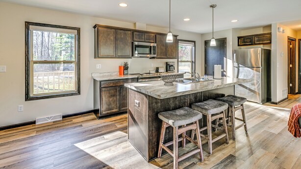 A modern kitchen with a large island, stainless steel appliances, and a view of the outdoors. - Golf, Hike & Boat: Home w/ Fire Pit in Friendship (Friendship)