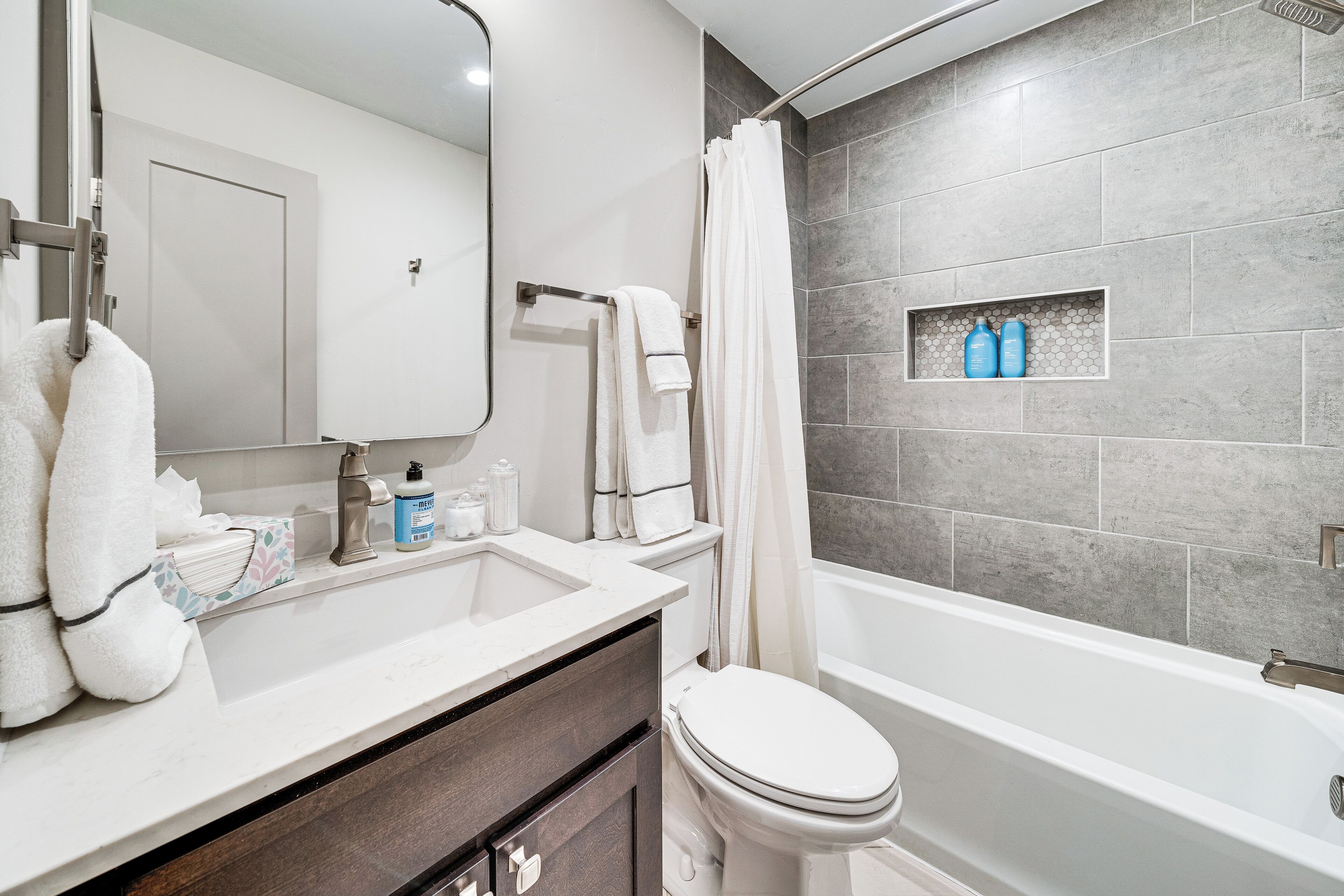 A bathroom with a bathtub, toilet, and sink.