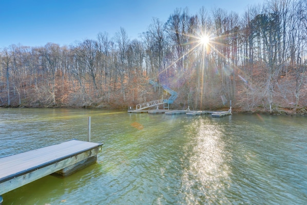 A wooden dock extending into a calm lake, surrounded by leafless trees and a clear sky. - Secluded Cabin w/ Dock Access in Pittsville (Pittsville)