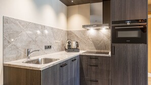 A modern kitchen with marble countertops, stainless steel sinks, and dark wood cabinets. - Superior 1-bedroom Apartment (Schruns)