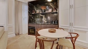 Una cocina moderna con salpicadero de mármol, armarios de madera y una mesa redonda con sillas.
