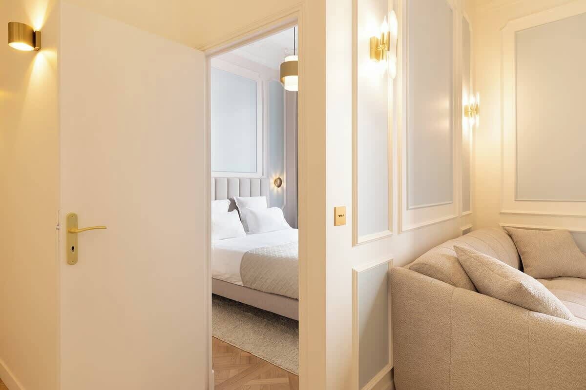 Ein Hotelzimmer mit einem Bett, einem Sofa und einer Tür zu einem weiteren Raum.