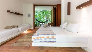 A hotel room with two single beds, a large bed, a hammock, and a view of greenery outside. - Atonishing 5BR Villa at Mesa de Yeguas (Anapoima)