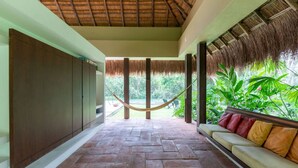 A covered outdoor area with a hammock, a sofa with cushions, and a view of greenery. - Atonishing 5BR Villa at Mesa de Yeguas (Anapoima)