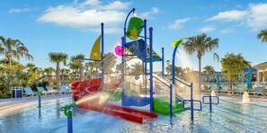 A water play area with slides and water jets, surrounded by palm trees and lounge chairs. - Family Friendly 5BR Home Pool Patio Room for 10 (Clermont)