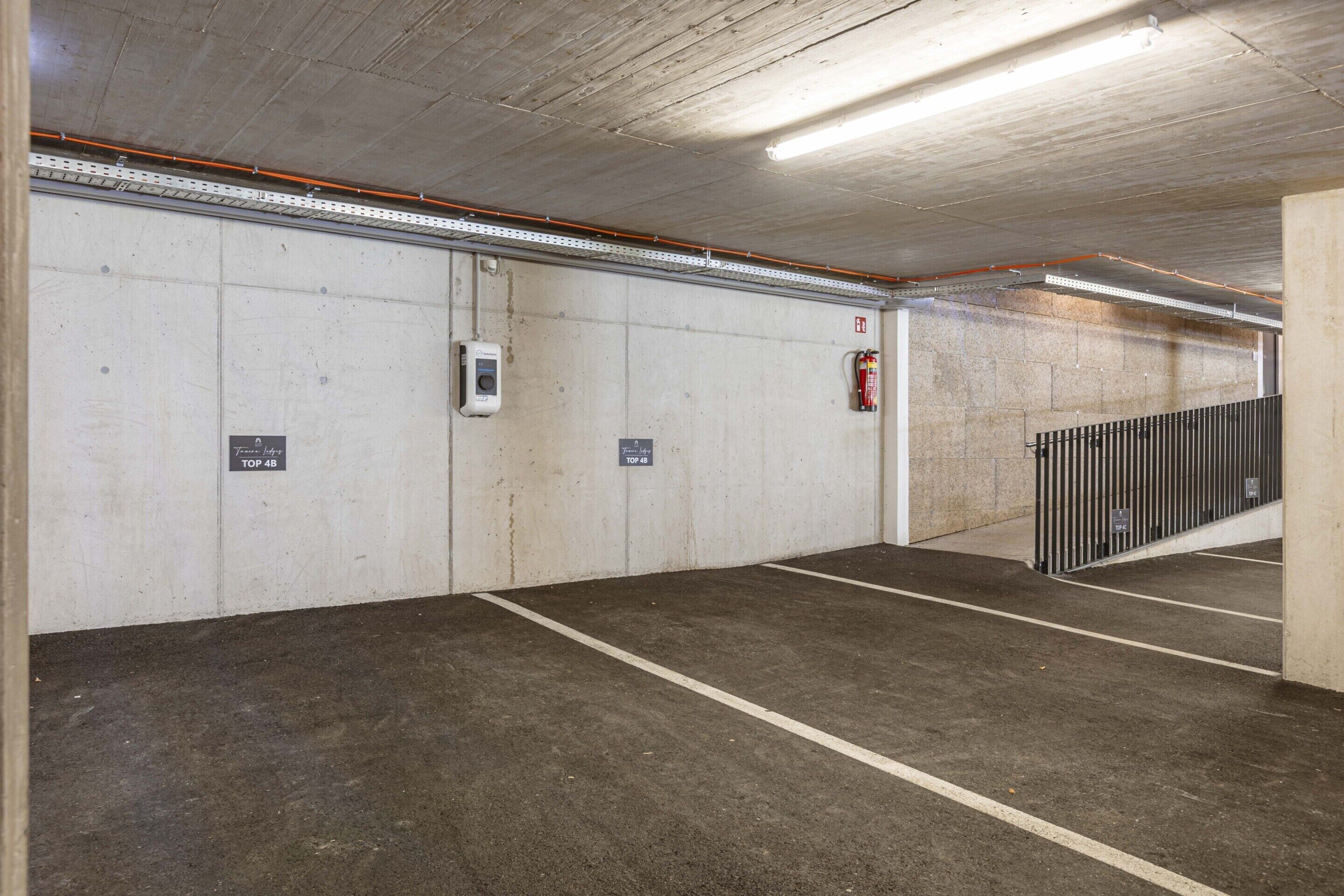 Eine Parkgarage mit Betonwänden, einem Feuerlöscher und einer Überwachungskamera.