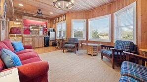 A cozy cabin interior with a kitchen, dining area, and seating.