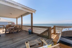 A wooden deck with a grill, outdoor seating, and a view of the ocean. - Still Waters - 2415 Bienville Blvd 4 Bedroom Home (Dauphin Island)