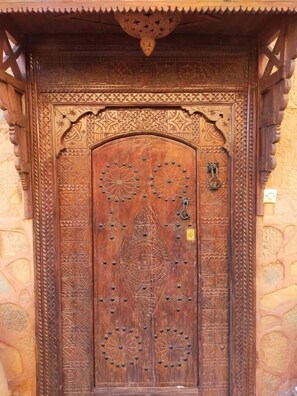A wooden door with intricate carvings and a metal knocker.