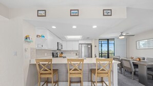 Eine moderne Küche mit einer zentralen Kochinsel, Holzkohle und einem Essbereich mit Tisch und Stühlen.