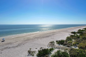 Ein Strand mit einer Holzpromenade und freiem Blick auf den Ozean.