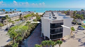 Ein modernes Hotel mit Innenhof, mehreren Etagen und Blick auf Strand und Meer.
