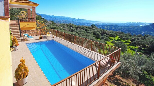 A swimming pool with a wooden deck and a metal railing, overlooking a mountainous landscape. - Fabulous villa, airco, pool, WIFI. Walking distance to village. Amazing views. (Comares)