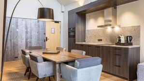 Eine moderne Küche mit dunklen Holzschränken, einer Marmorarbeitsplatte und einem eingebauten Ofen.