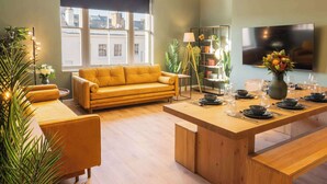 Un salon moderne avec un canapé, une table basse en bois et une bibliothèque.