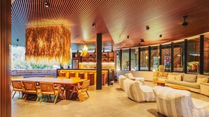 Un intérieur moderne comprenant un coin repas, des canapés et un bar.