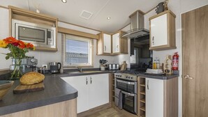 A compact kitchen with a built-in oven, microwave, and stove.