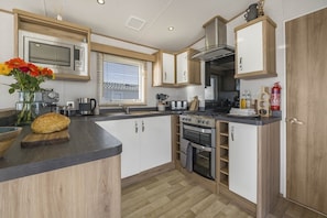 A compact kitchen with a built-in oven, microwave, and stove.