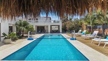 Una piscina al aire libre, sombrillas, tumbonas