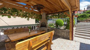 An outdoor wooden pergola with a stone bench and a pizza oven. - Adorable Home With Swimming Pool and sea View (Senj)