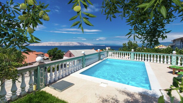 A swimming pool with a view of the sea, surrounded by a white balustrade and greenery. - Adorable Home With Swimming Pool and sea View (Senj)
