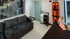 A reception area with a sofa, a counter, and a fire extinguisher. - HOTEL CASA FLORIDA (Medellín)