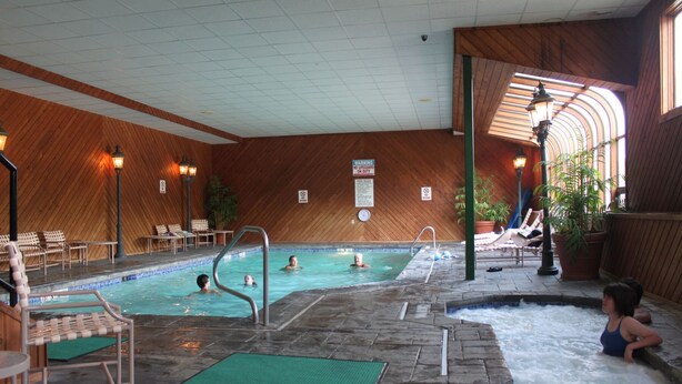 An indoor swimming pool with multiple lanes, a hot tub area, and lounge seating. - # 127 Two Bedroom Condo with private entry (Lincoln)