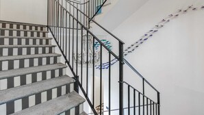 A staircase with black railings and striped steps. - Bright Ground-floor Studio in Milan (Milan)