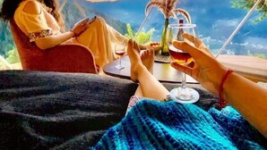 Una persona recostada en un sofá con vista a un paisaje montañoso a través de una ventana.